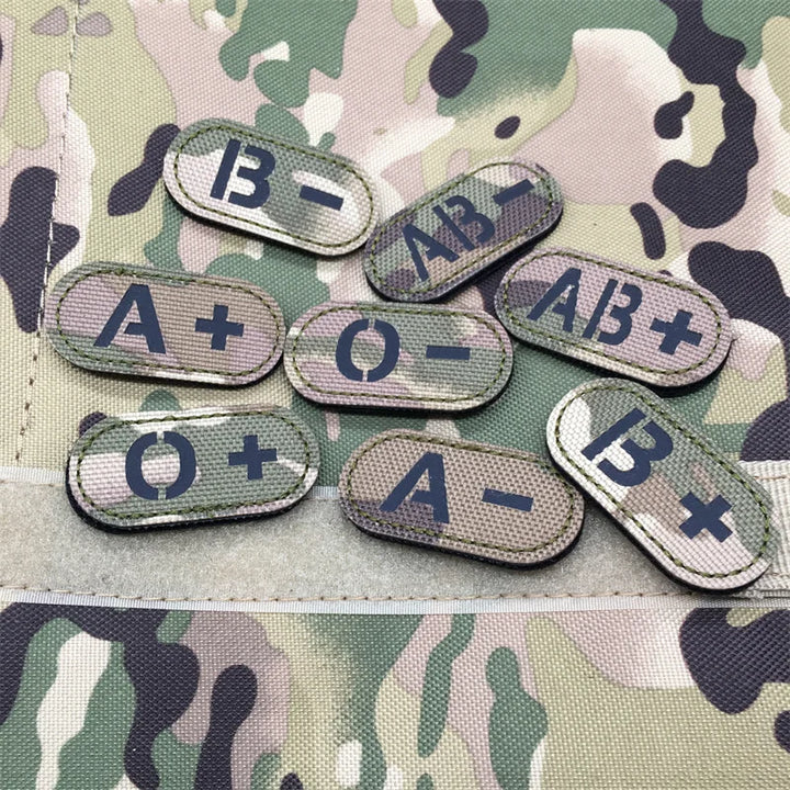 Set of multicam tactical blood type hook and loop patches with black lettering approximately 4.8x2.4cm on a camouflage background