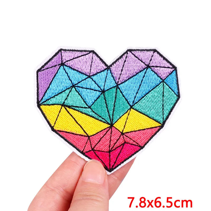 Geometric heart-shaped patch held by a hand with dimensions displayed