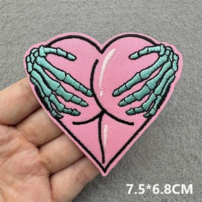 Heart-shaped patch with skeleton hands on a pink background held by a hand, with size 7.5*6.8CM displayed.
