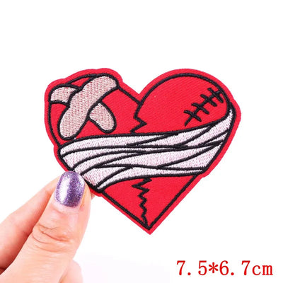 Heart-shaped patch with bandage design held by a hand on a white background