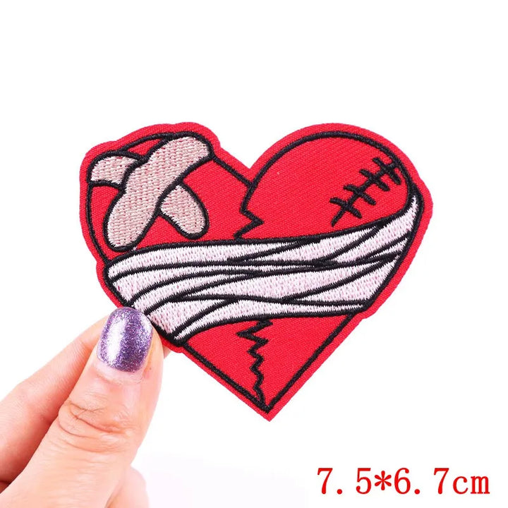 Heart-shaped patch with bandage design held by a hand on a white background