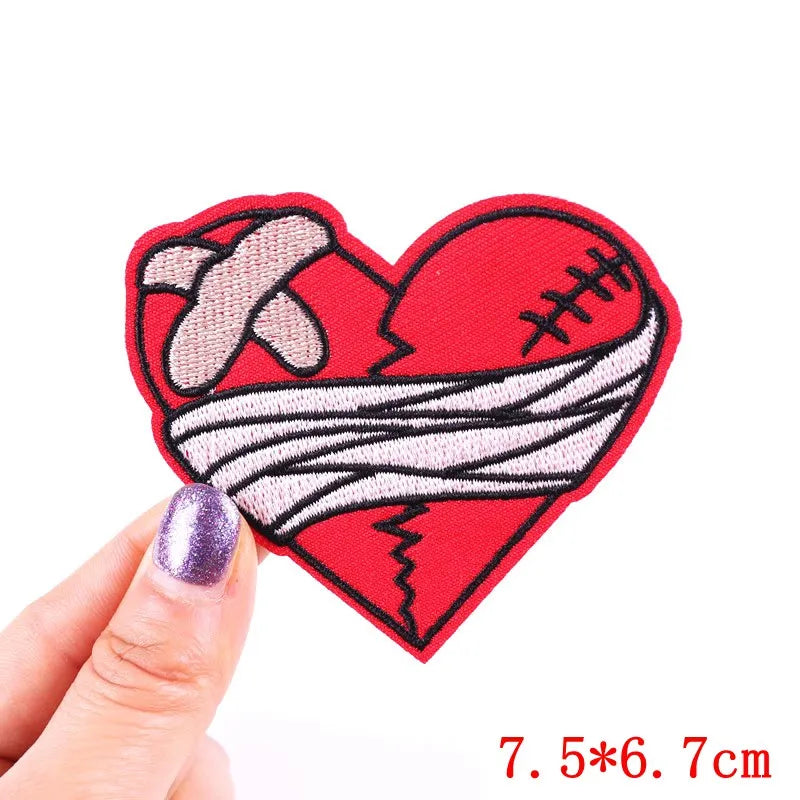 Heart-shaped patch with bandage design held by a hand on a white background