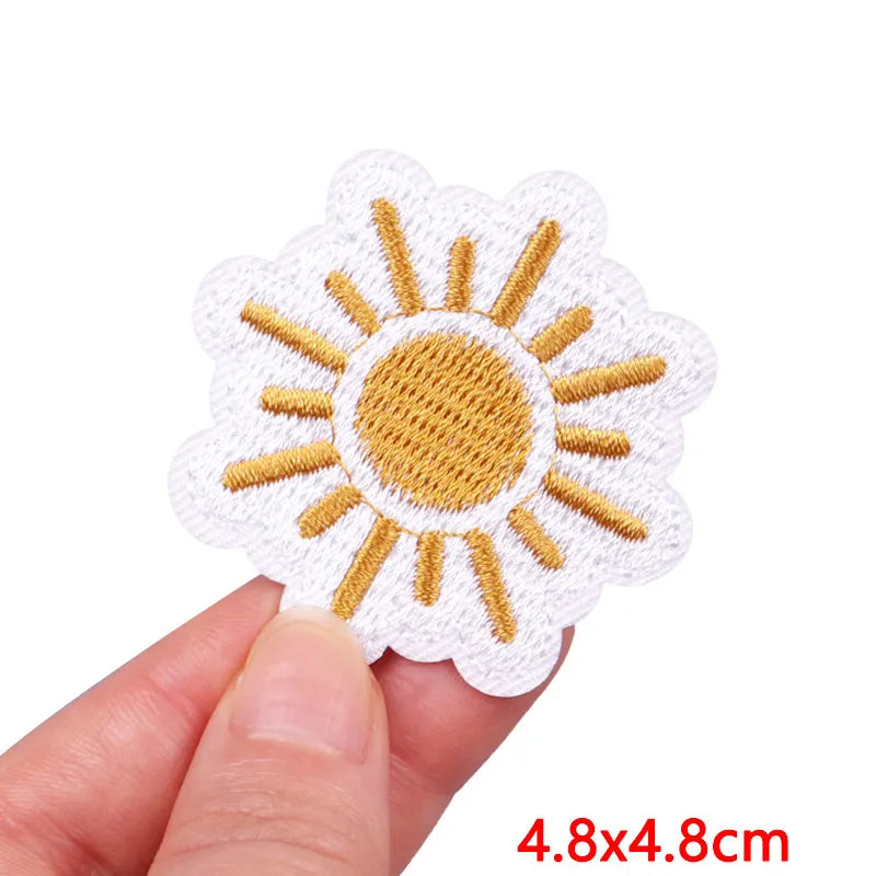 Sun-shaped patch held by a hand with dimensions displayed