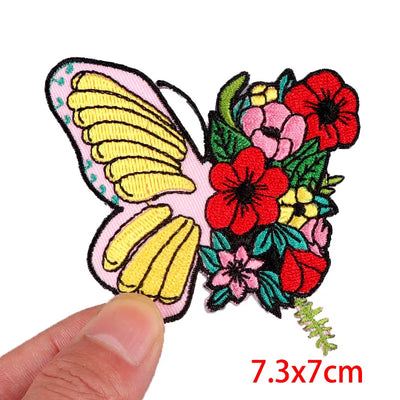 Colorful butterfly and floral patch held by a hand with dimensions '7.3x7cm' displayed.