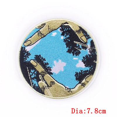 Circular patch with hands holding a landscape design on a white background