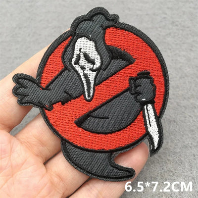 Embroidered patch with a raven design held in a hand on a gray background