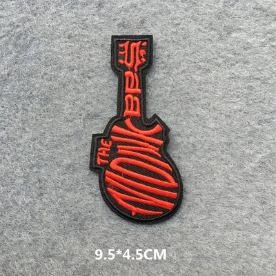 Red and black guitar-shaped patch on a gray background