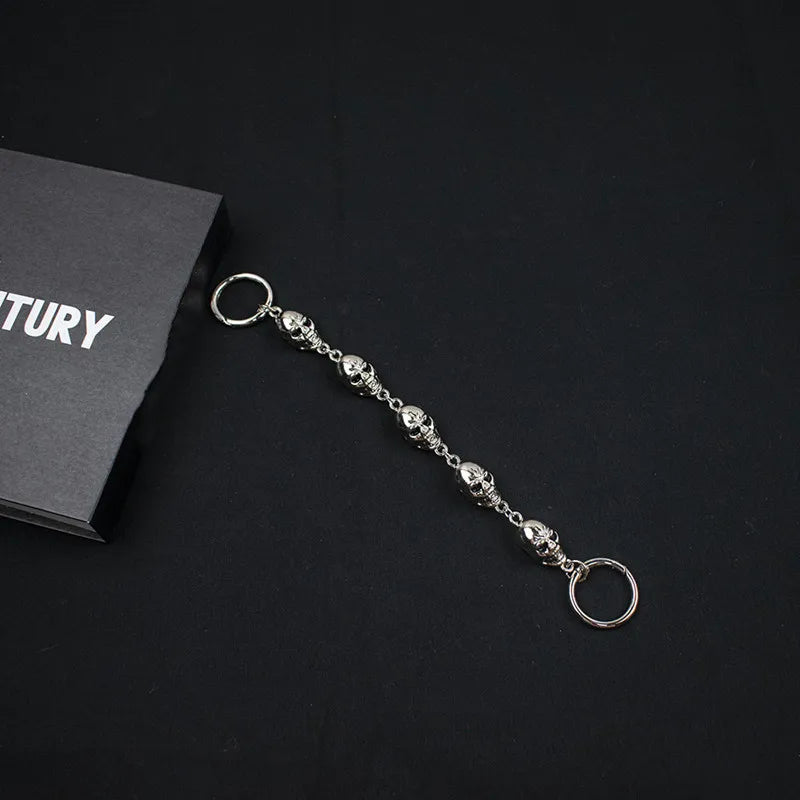 Silver chain for crocs on a black surface with a black card in the background