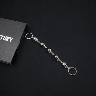 Silver chain for crocs on a black surface with a black card in the background