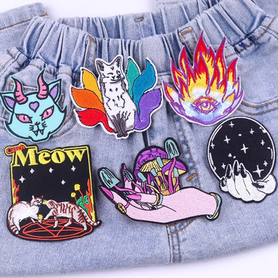Collection of colorful embroidered patches on a denim fabric background