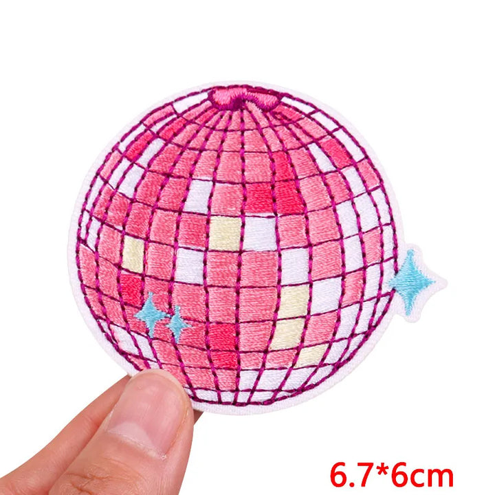 Pink grid-patterned ball held by a hand with measurement text &