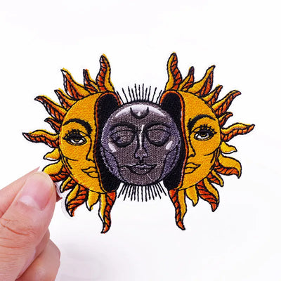 Patch with sun and moon design held by a hand on a white background