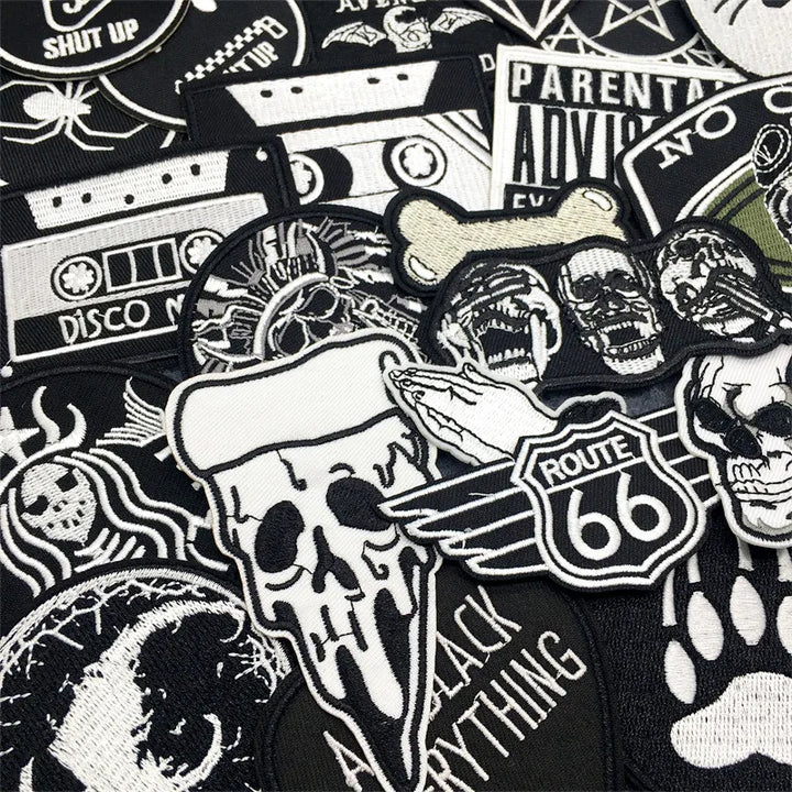 Collection of various black and white patches with different designs on a black background.