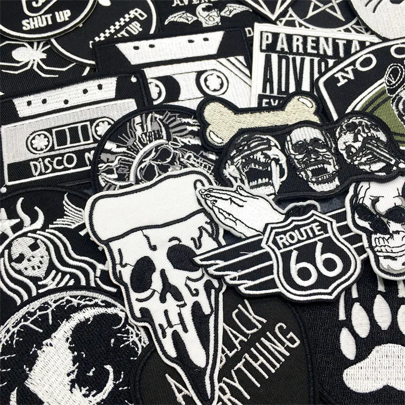 Collection of various black and white patches with different designs on a black background.