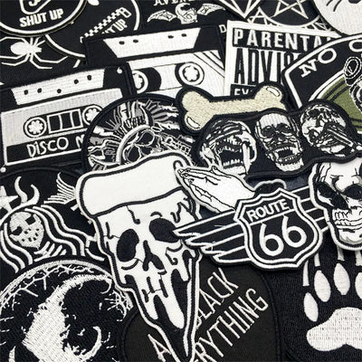 Collection of various black and white patches with different designs on a black background.