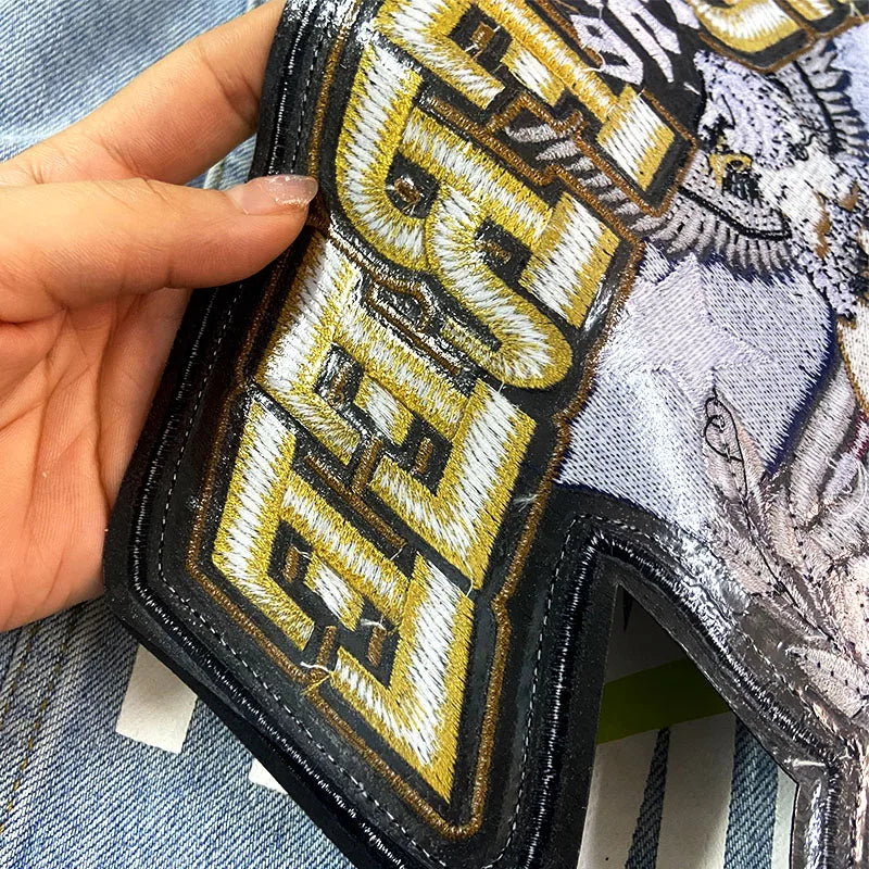 Hand holding a wallet with a gold and black 'BREXIT' patch on a denim background