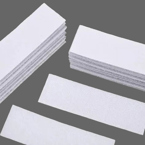 Set of white adhesive Velcro patches on a gray background