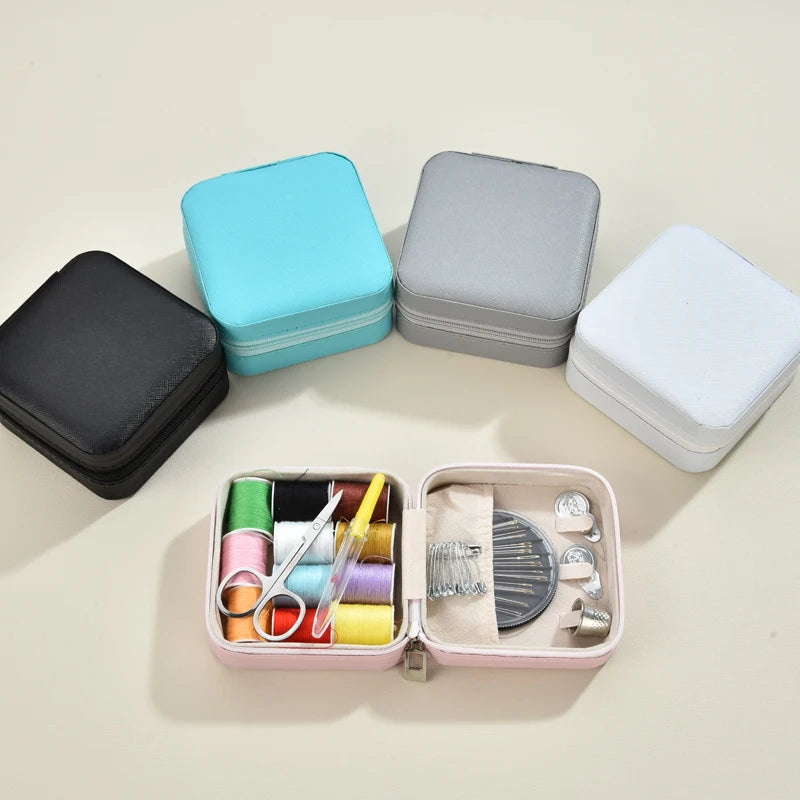 Set of sewing kits with colorful thread and tools on a light surface