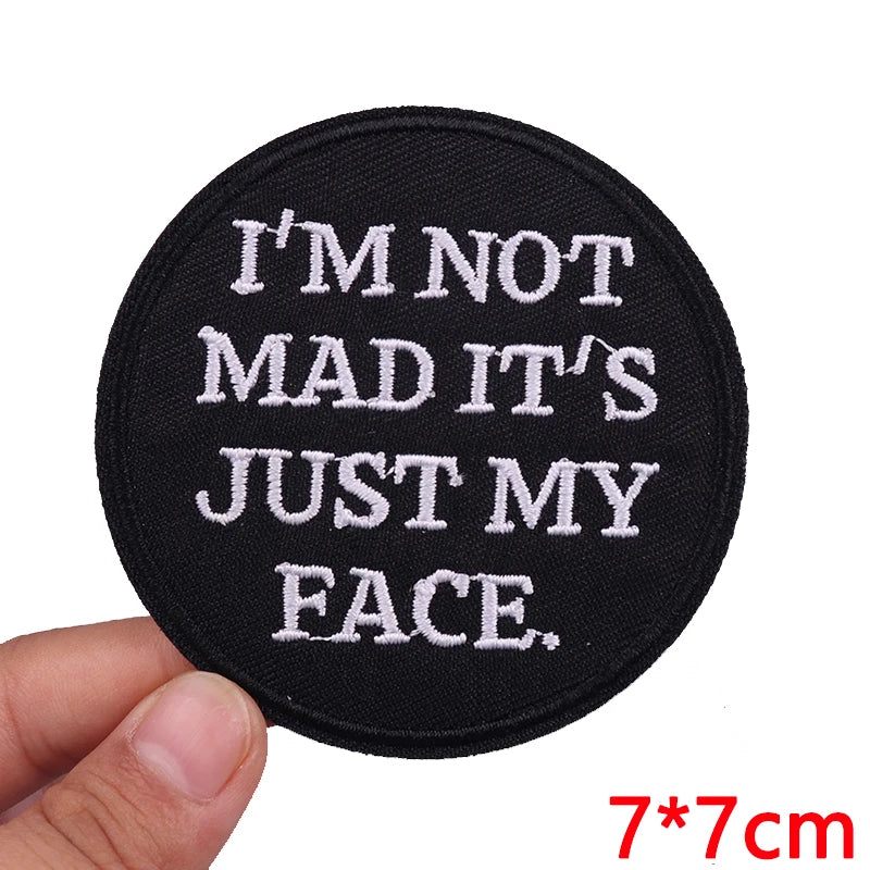 Black patch with white text 'I'M NOT MAD IT'S JUST MY FACE.' held by a hand, with size '7*7cm' displayed.