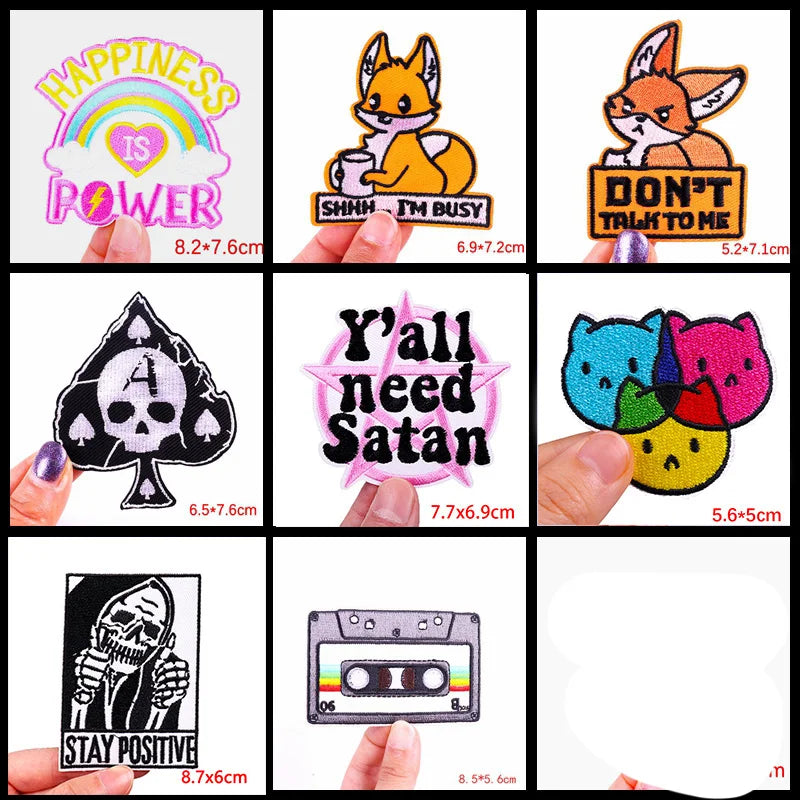 Collection of various patches with different designs and text, held by hands.
