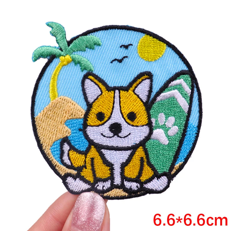 Embroidered patch of a corgi dog with a tropical background held by a hand.
