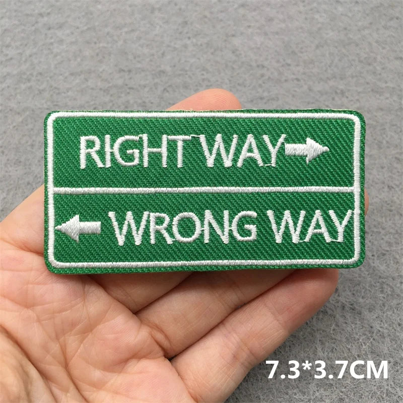 Embroidered patch with 'Right Way' and 'Wrong Way' text held in a hand against a gray background.