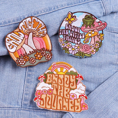 Three colorful embroidered patches on a denim jacket.