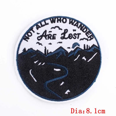 Circular patch with 'Not All Who Wander Are Lost' text and mountain design on a white background.