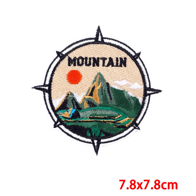 Mountain-themed patch with embroidered design on a beige background