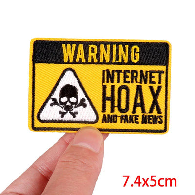 Patch with 'WARNING: INTERNET HOAX AND FAKE NEWS' text held by a hand, with dimensions displayed.