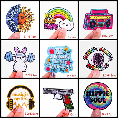 Collection of colorful stickers with various designs held by fingers, showing dimensions.
