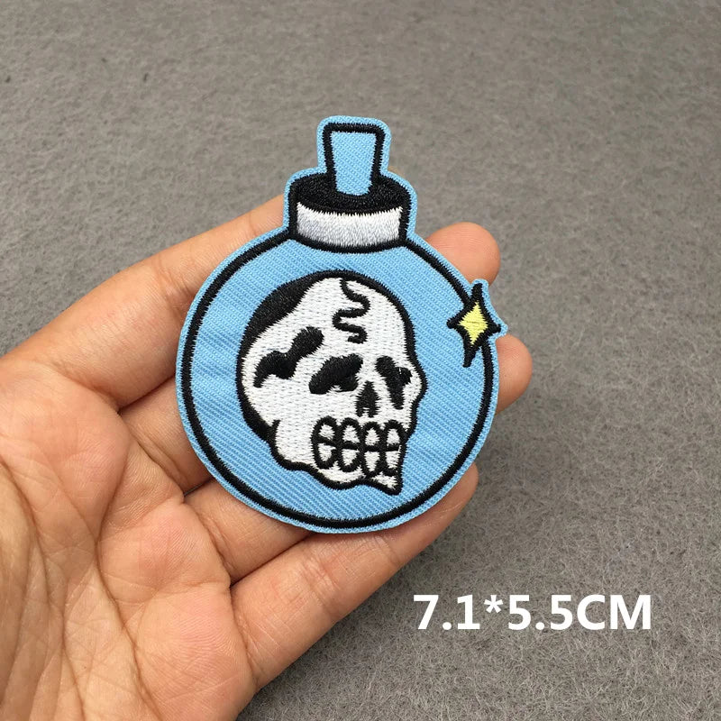 Skull design patch held in a hand with a gray background