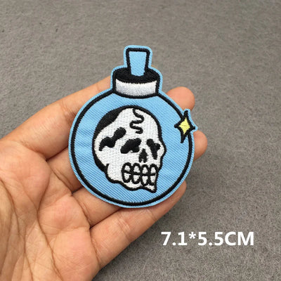 Skull design patch held in a hand with a gray background
