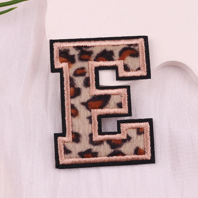 Leopard print letter 'E' patch on a light fabric background