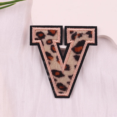 Leopard print letter 'V' patch on a white fabric background