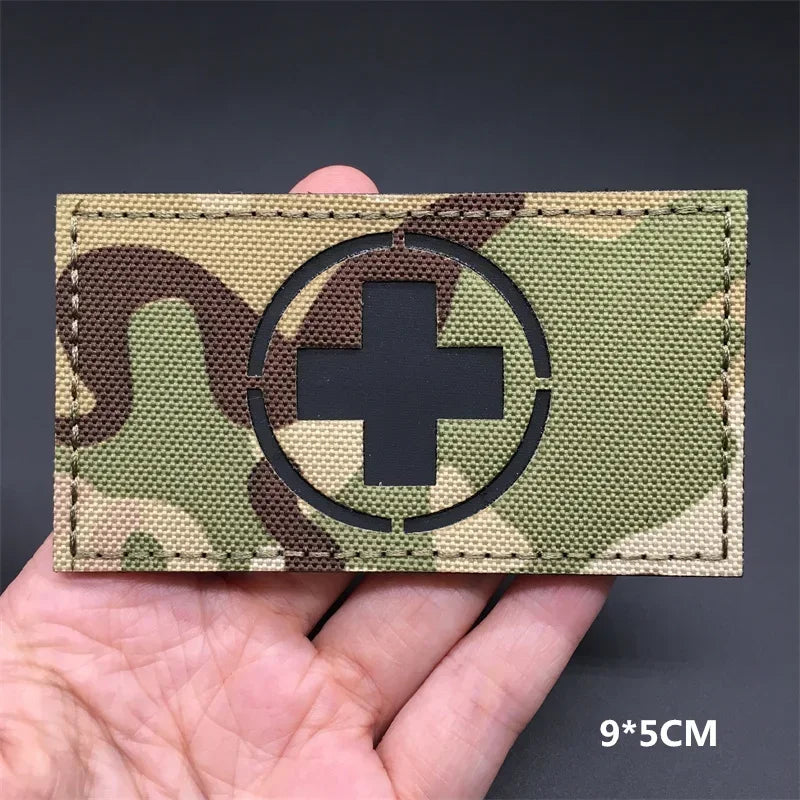 Switzerland flag Camouflage patch  held in a hand against a dark background