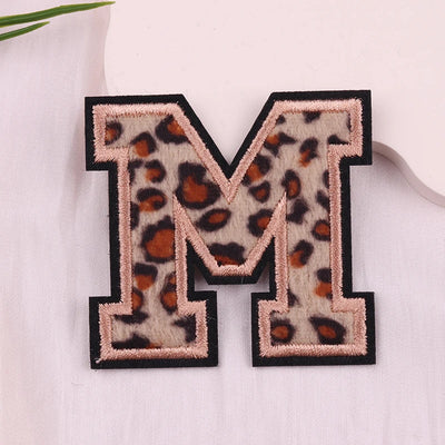 Leopard print letter 'M' patch on a white background