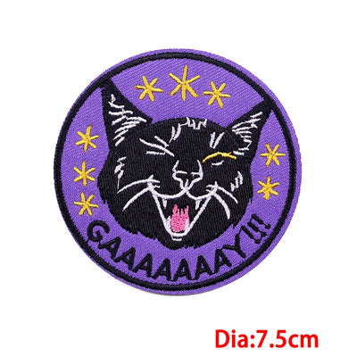 Circular patch with a black cat design and yellow stars on a purple background, with text 'GAAAAAAAY' and diameter 7.5cm.