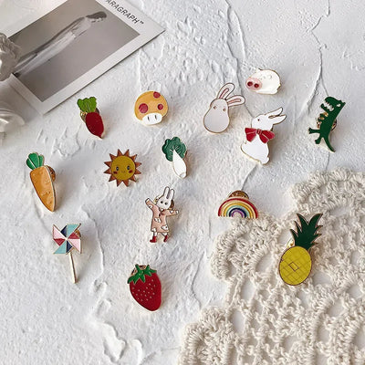 Collection of colorful enamel pins on a textured white surface with a photo frame in the background.