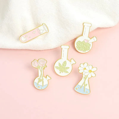 Set of decorative pins featuring scientific-themed designs on a pink background
