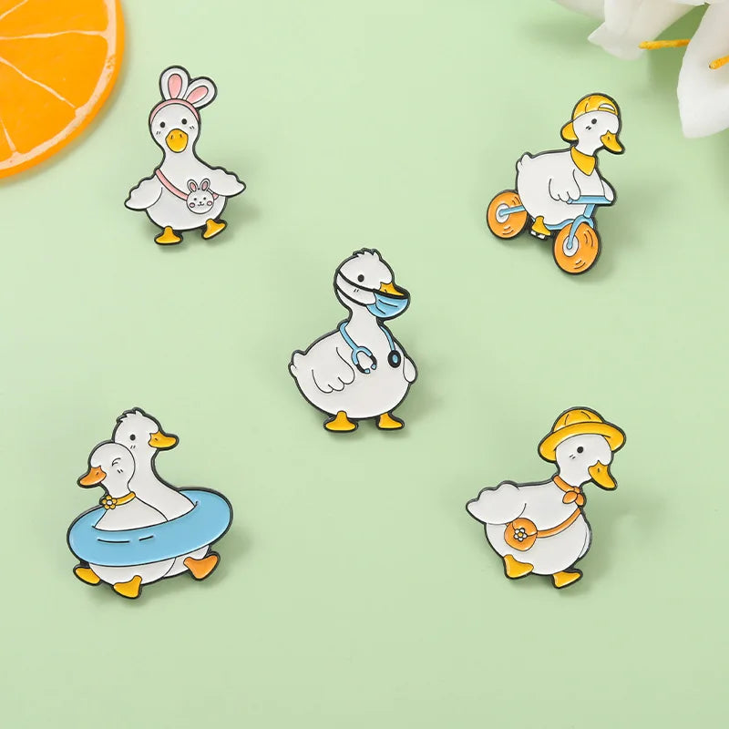 Set of cartoon duck pins on a light green background