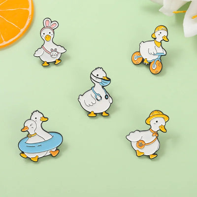 Set of cartoon duck pins on a light green background