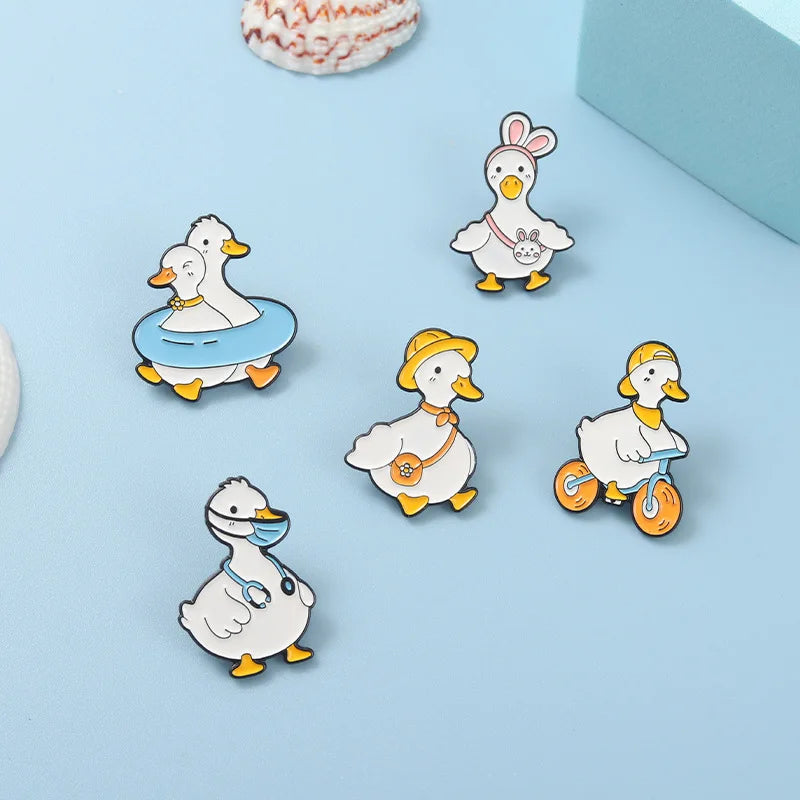 Set of cartoon duck pins on a light blue background