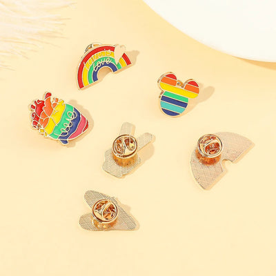Set of rainbow-themed pins on a light yellow background