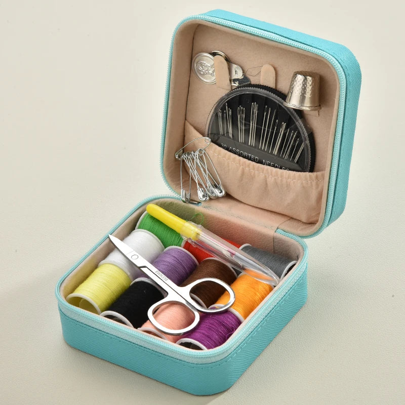 Blue Sewing kit with colorful threads, scissors, and other tools in a teal case on a beige background