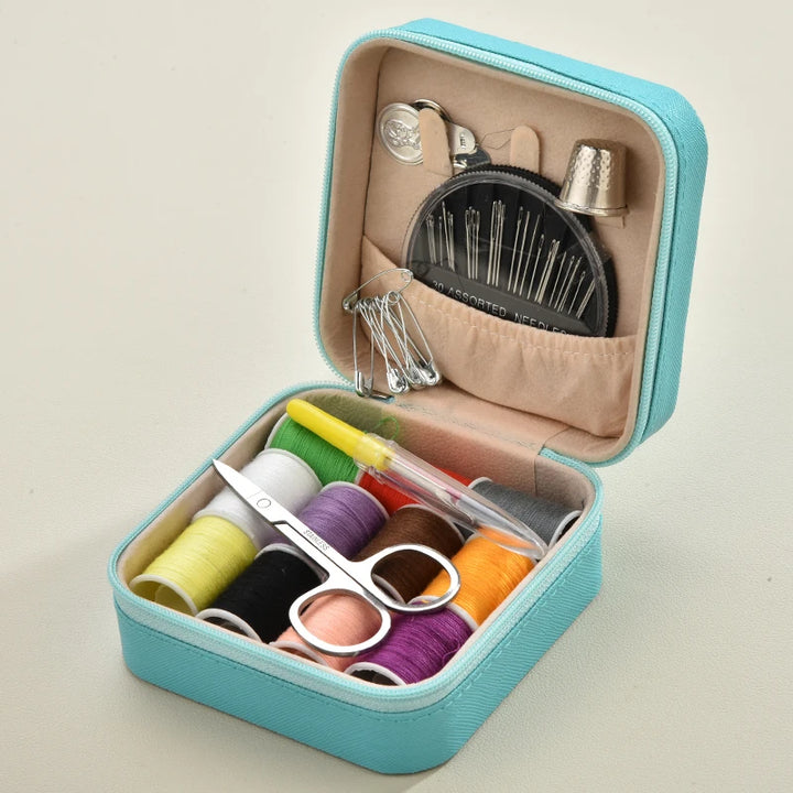 Blue Sewing kit with colorful threads, scissors, and other tools in a teal case on a beige background