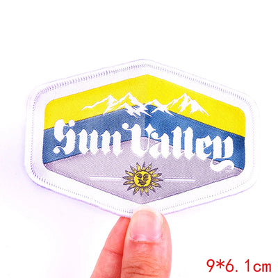 Hexagonal patch with 'Sun Valley' text and mountain design held by a finger on a white background.