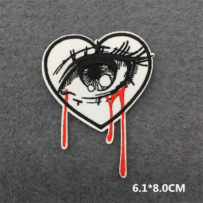 Heart-shaped patch with an eye design on a gray background