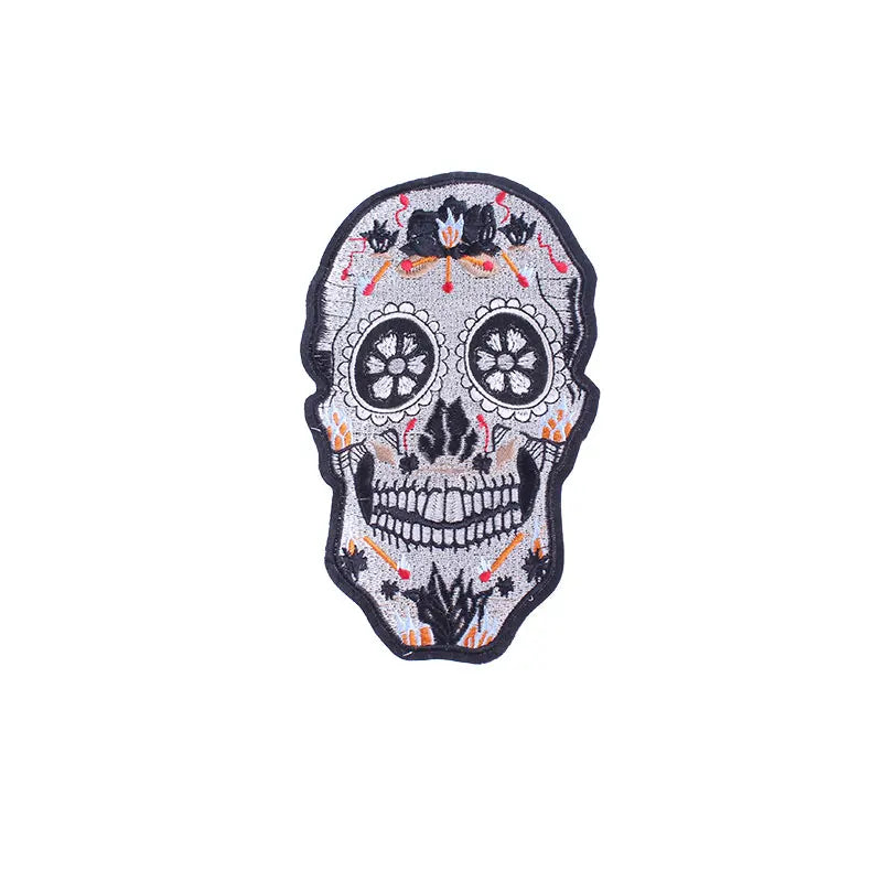 Decorative skull patch with floral details on a white background