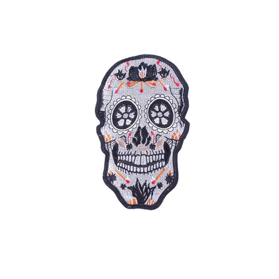 Decorative skull patch with floral details on a white background